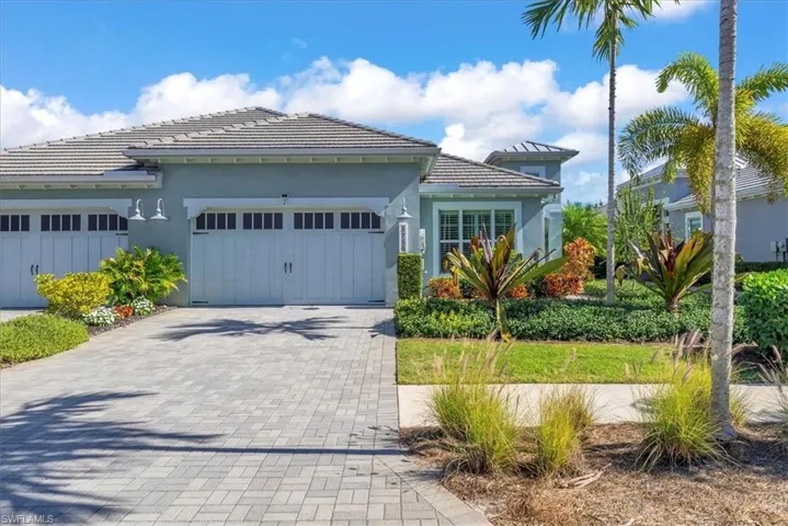 View of front of home with stucco siding, decorative driveway, and an attached garage
