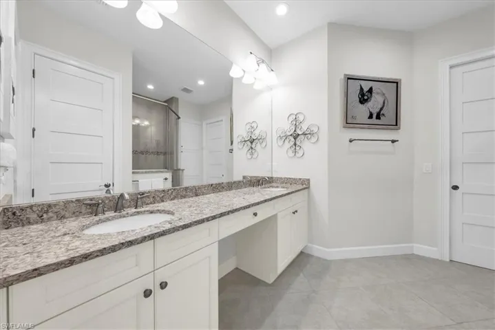 Bathroom with vanity, shower / tub combo with curtain, and dark wood-type flooring