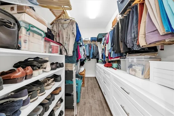 Laundry room with light wood-style floors, cabinet space, and washing machine and dryer