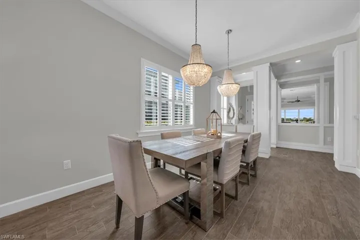 Dining area with wood finished floors, ceiling fan, crown molding, recessed lighting, and a chandelier