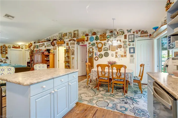 Kitchen with visible vents, lofted ceiling, light countertops, light wood-style floors, and stainless steel dishwasher