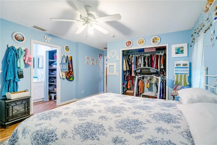 Bedroom with visible vents, baseboards, ceiling fan, light wood-style flooring, and a closet