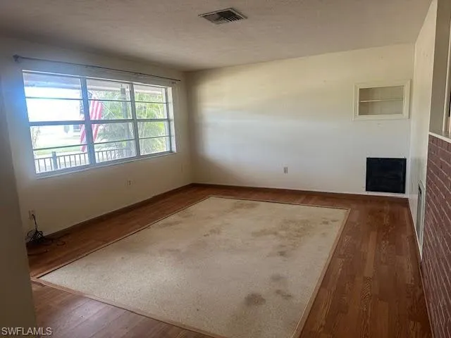 Living room featuring dark hardwood / wood-style and terrazzo floors and a textured ceiling