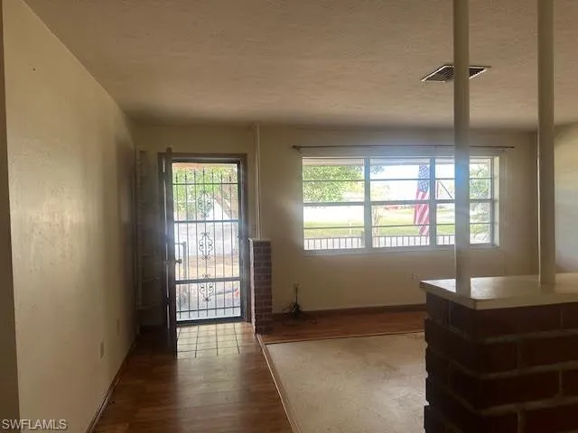 Foyer entrance with wood-type flooring and terrazzo and a textured ceiling