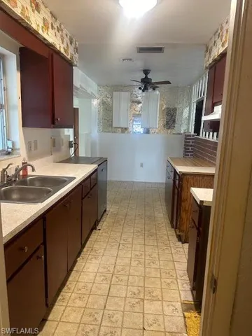 Kitchen featuring dark brown cabinetry, sink, stainless steel dishwasher, and ceiling fan