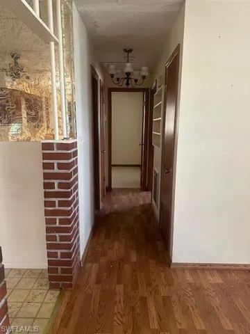 Hall featuring hardwood / wood-style floors and a chandelier