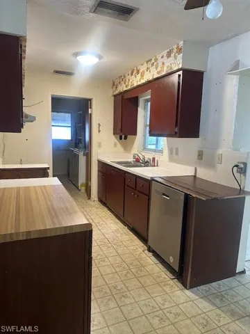 Kitchen featuring ceiling fan, stainless steel dishwasher, and sink