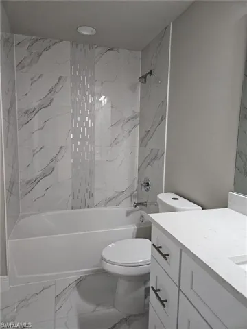 Full bathroom with vanity, toilet, and tiled shower / bath