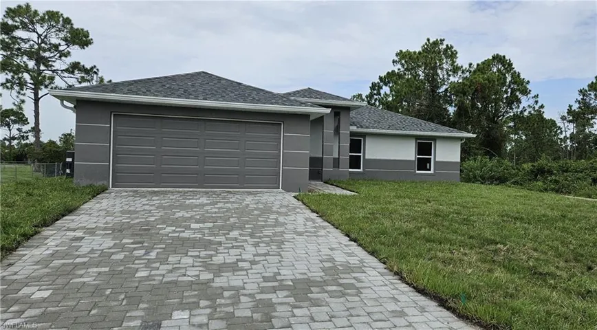 View of front of house with a front lawn and a garage