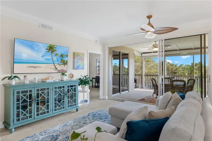 Living room with plenty of natural light, ornamental molding, and ceiling fan