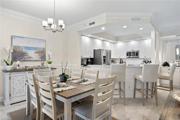 Dining area featuring ornamental molding, an inviting chandelier, and light hardwood / wood-style floors