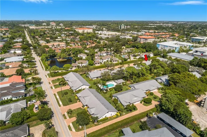 Aerial view of property and surrounding area featuring a nearby body of water and nearby suburban area