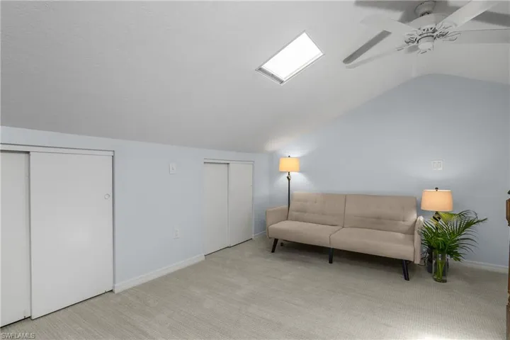 Sitting room featuring lofted ceiling, carpet flooring, and ceiling fan