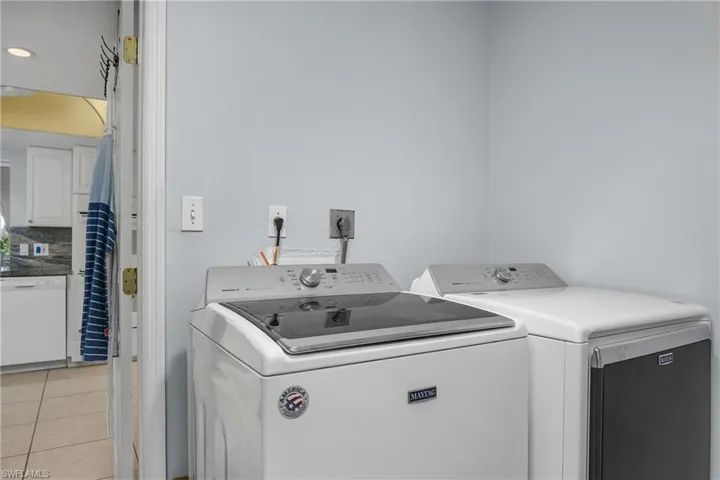 Laundry room with light tile patterned floors and independent washer and dryer