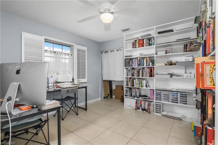 Home office featuring light tile patterned flooring and a ceiling fan