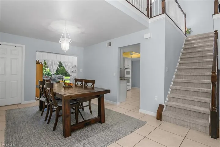 Dining area featuring light tile patterned floors and stairway