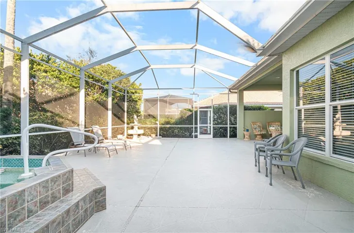 View of patio with a lanai, and an outdoor spa