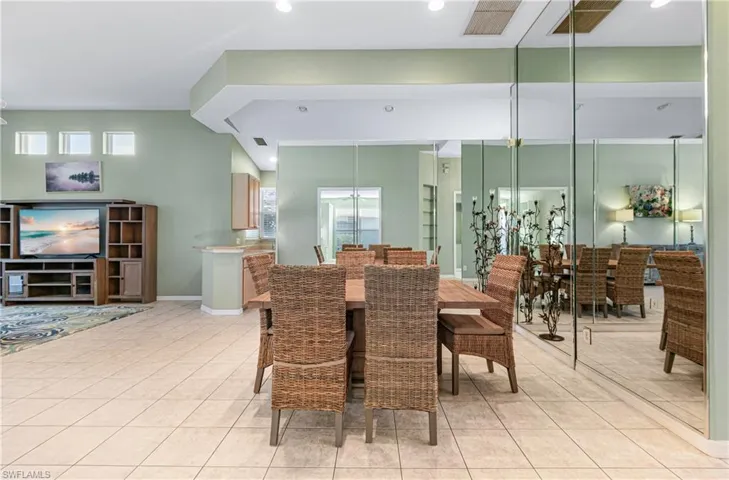 Dining space with light tile patterned floors and recessed lighting and mirrors
