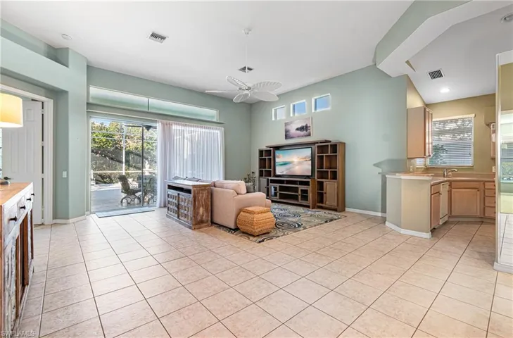 Living area featuring ceiling fan, light tile patterned floors, and plenty of natural light