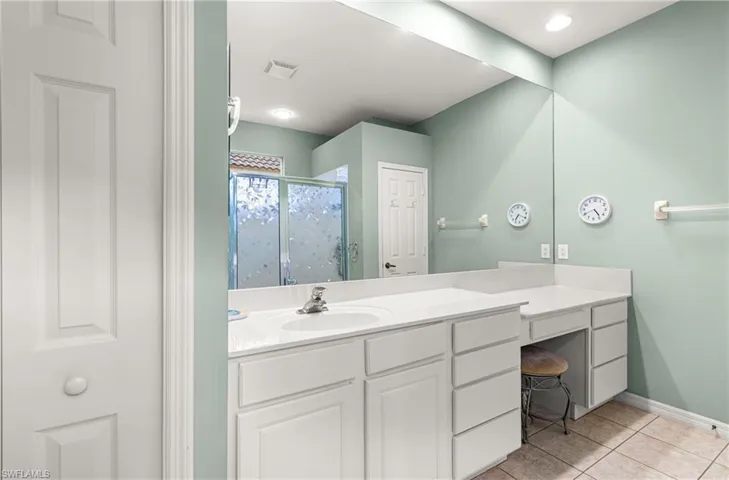 Full bath featuring vanity, a stall shower, and light tile patterned floors