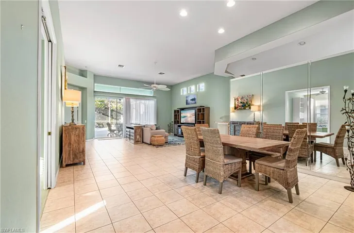 Dining/living area with ceiling fan, mirrors, light tile patterned floors, and recessed lighting