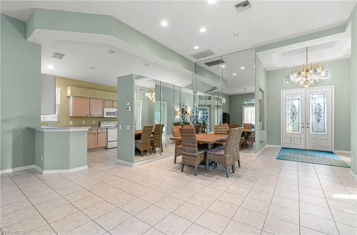 Dining/entry/kitchen space with a chandelier and light tile patterned floors