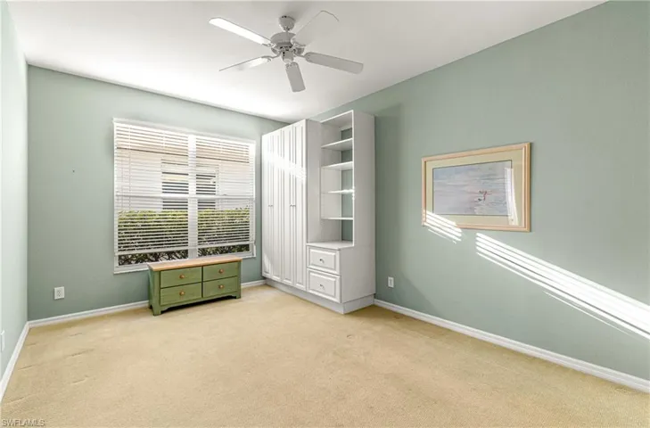 Den with large window and custom built in storage.
