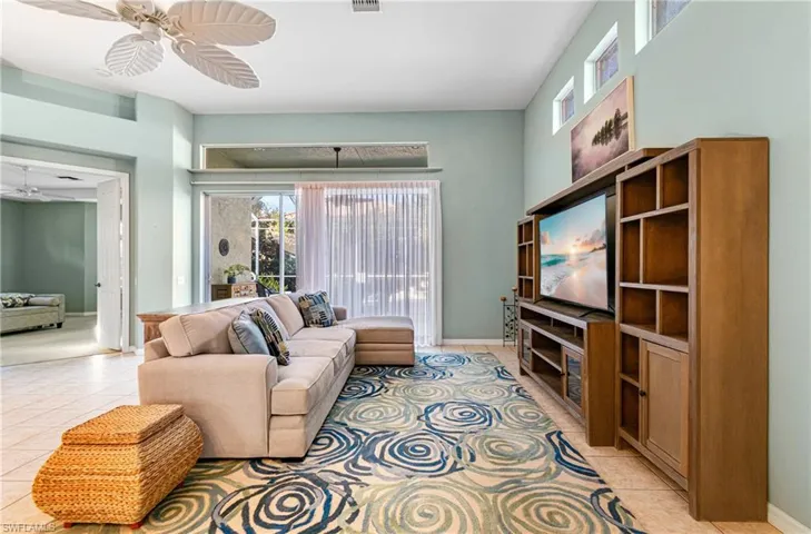 Living area with ceiling fan and light tile patterned flooring