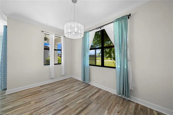 Empty room featuring hardwood / wood-style flooring, crown molding, and a wealth of natural light
