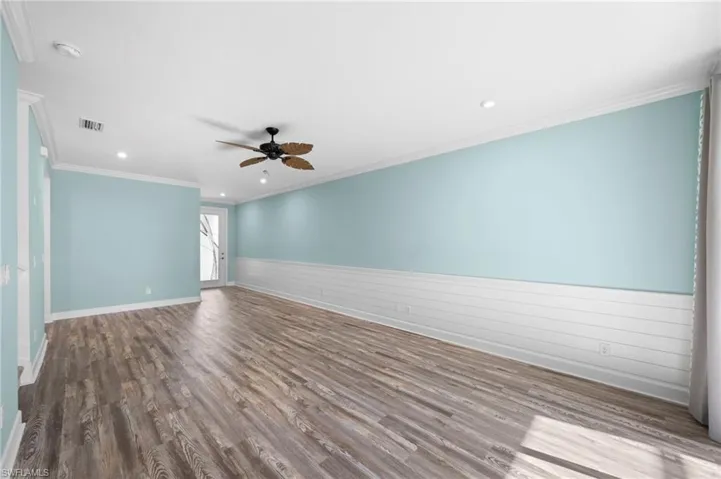 Empty room featuring ceiling fan, hardwood / wood-style flooring, and crown molding