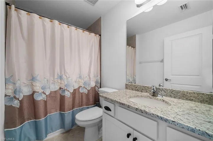 Bathroom with walk in shower, vanity, and toilet