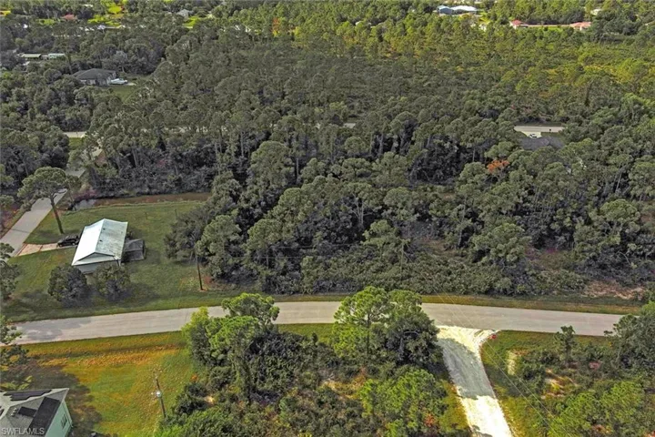 Aerial view of property's location with a heavily wooded area