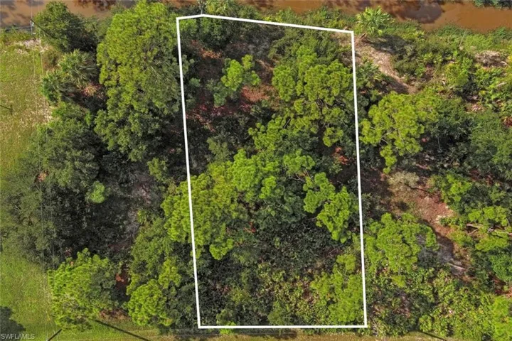 Aerial view of property and surrounding area featuring property boundaries highlighted