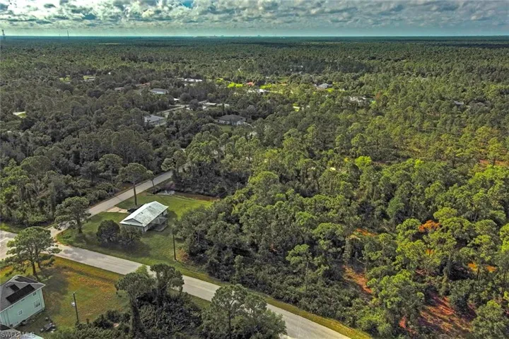 Aerial overview of property's location with a heavily wooded area
