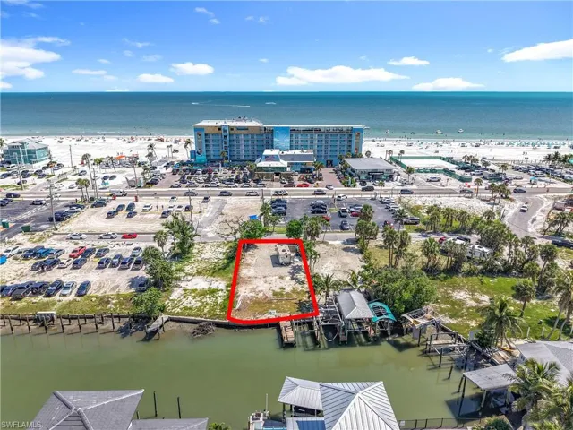 Aerial view of property and surrounding area featuring a large body of water and property boundaries highlighted