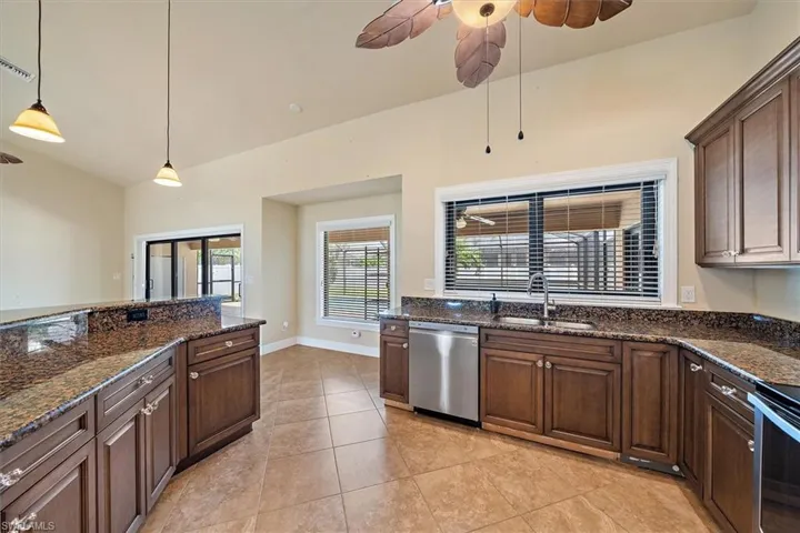 Kitchen with ceiling fan, stainless steel dishwasher, light tile flooring, pendant lighting, and sink