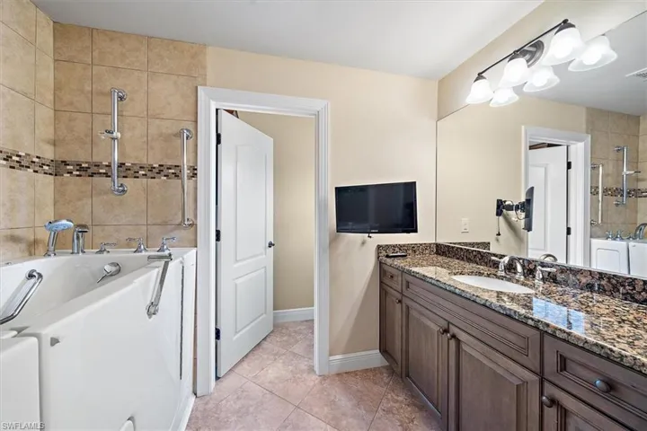 Guest Bathroom featuring tile flooring, independent shower and walk-in jetted bathtub, and vanity