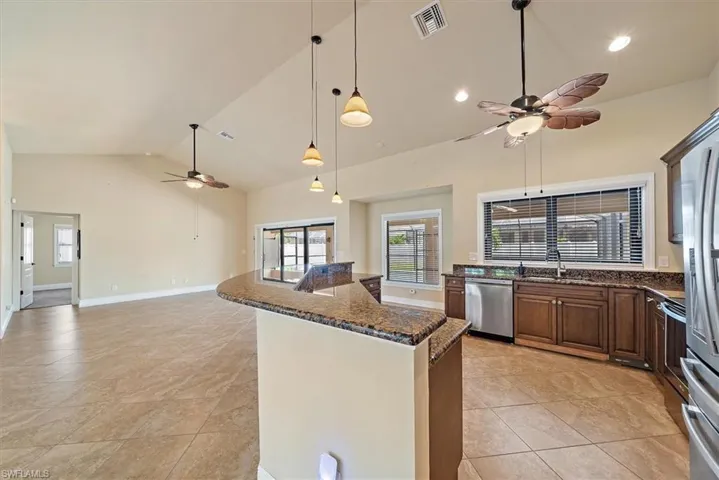 Kitchen with ceiling fan, stainless steel dishwasher, and light tile floors