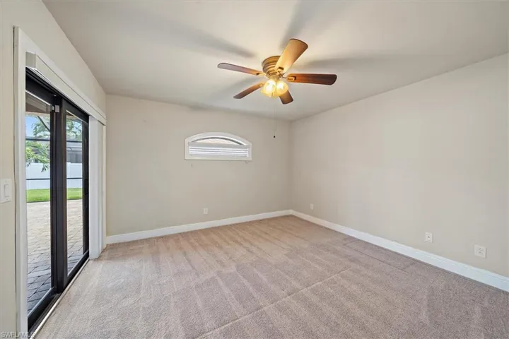 Carpeted  bedroom 3 featuring ceiling fan and access to pool