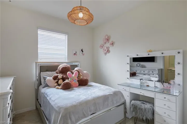Charming Bedroom with light tile patterned flooring and baseboards