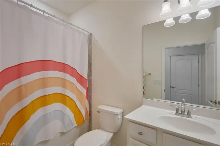 Full bathroom with a shower with curtain, toilet, and vanity