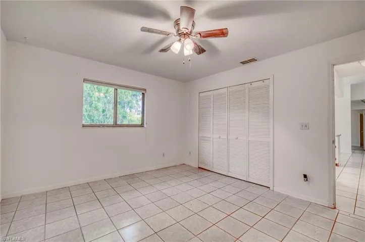 Unfurnished bedroom featuring light tile patterned flooring, a closet, and ceiling fan