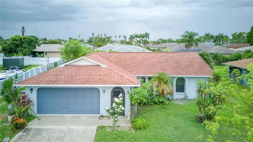View of front of property featuring a garage and a front lawn