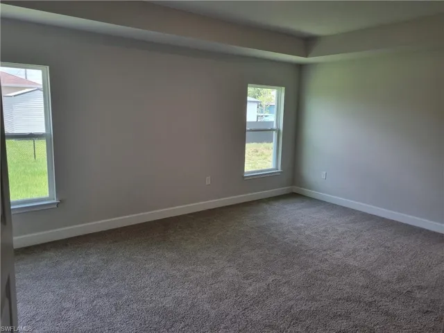 Carpeted empty room featuring baseboards