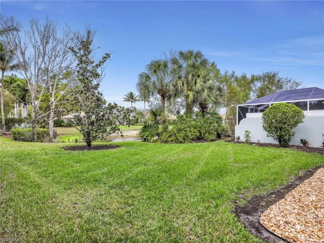 View of green lawn featuring a lanai and a sunroom