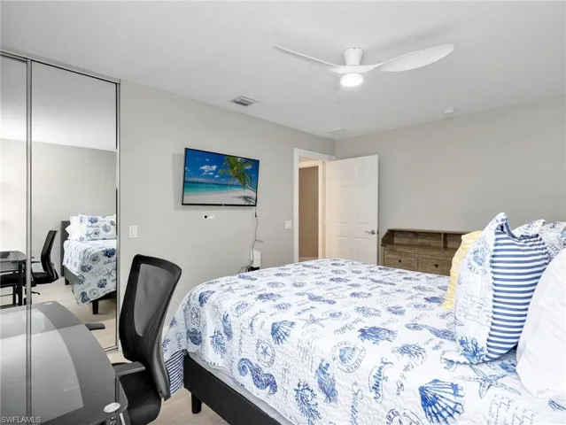 Bedroom with light wood-type flooring, ceiling fan, and a closet