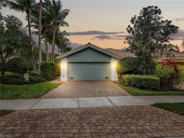 View of front facade featuring decorative driveway, stucco siding, and an attached garage