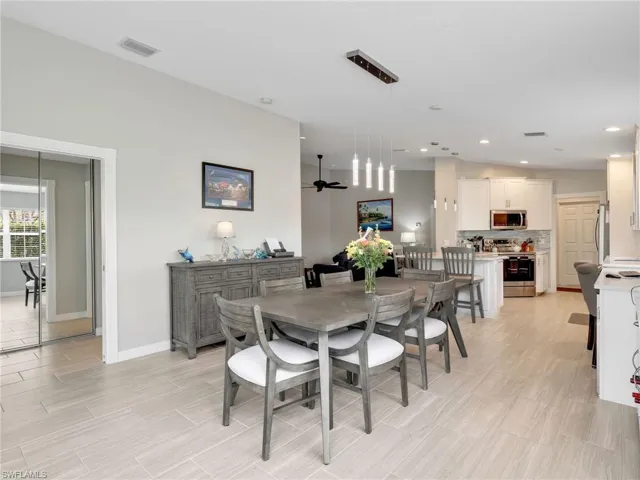 Dining space with a ceiling fan, wood tiled floors, and recessed lighting
