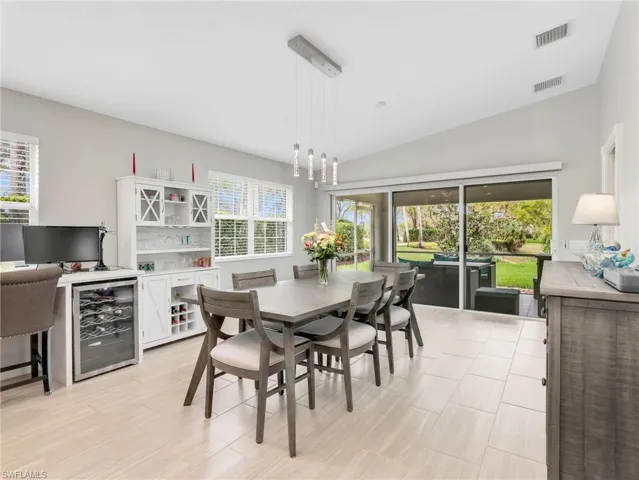 Dining area with lofted ceiling, healthy amount of natural light, and wine cooler