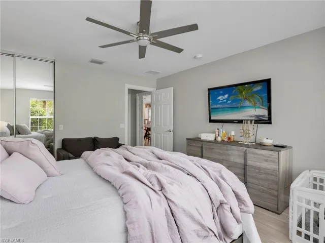 Bedroom with a ceiling fan, light wood-type flooring, and a closet